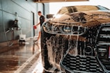 a man washing a sports car in a garage