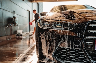 a man washing a sports car in a garage