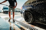 a man is washing a car with a hose