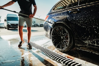 a man is washing a car with a hose