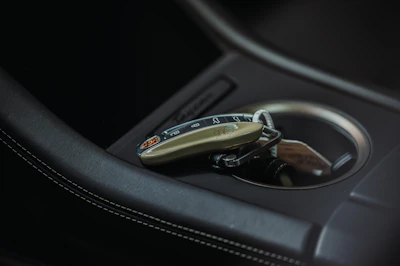 Close-up of a luxury car key fob resting on a sleek dashboard.