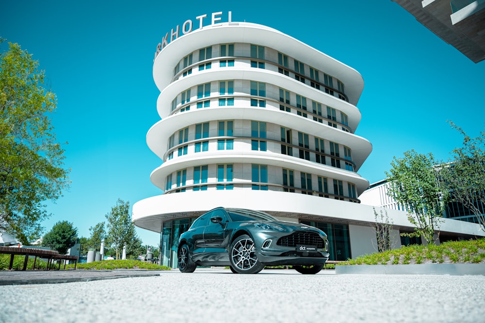 a black car parked in front of a hotel