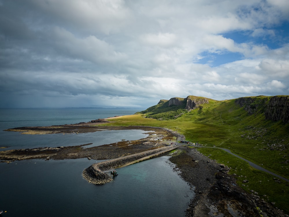 a large body of water surrounded by a lush green hillside