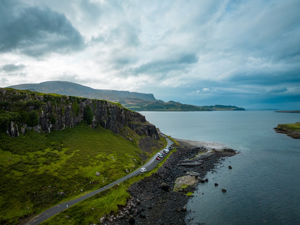 a car driving down a road next to a large body of water