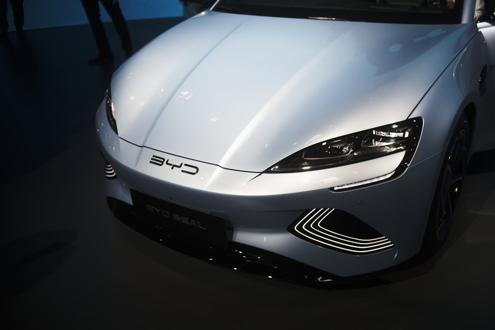 a white sports car is on display at a car show