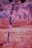 A dreamlike scene featuring trees with branches extending in various directions, set against a field of grass. The surreal coloration includes shades of pink, purple, and hints of orange, creating a visually striking and otherworldly appearance.