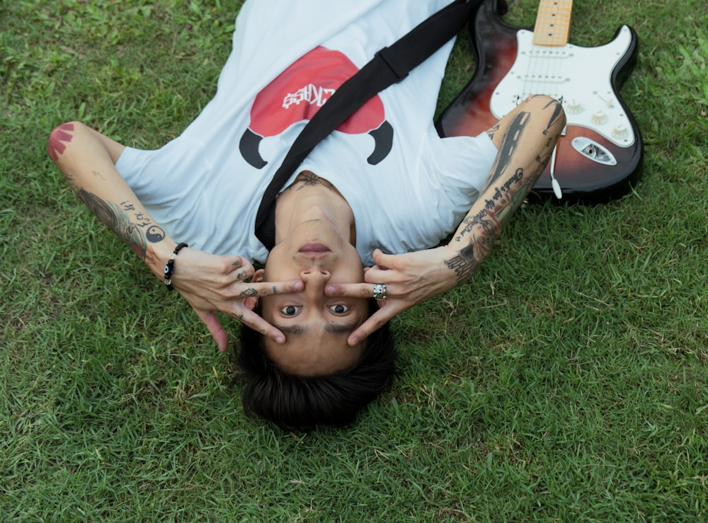 a person laying on the ground with a guitar