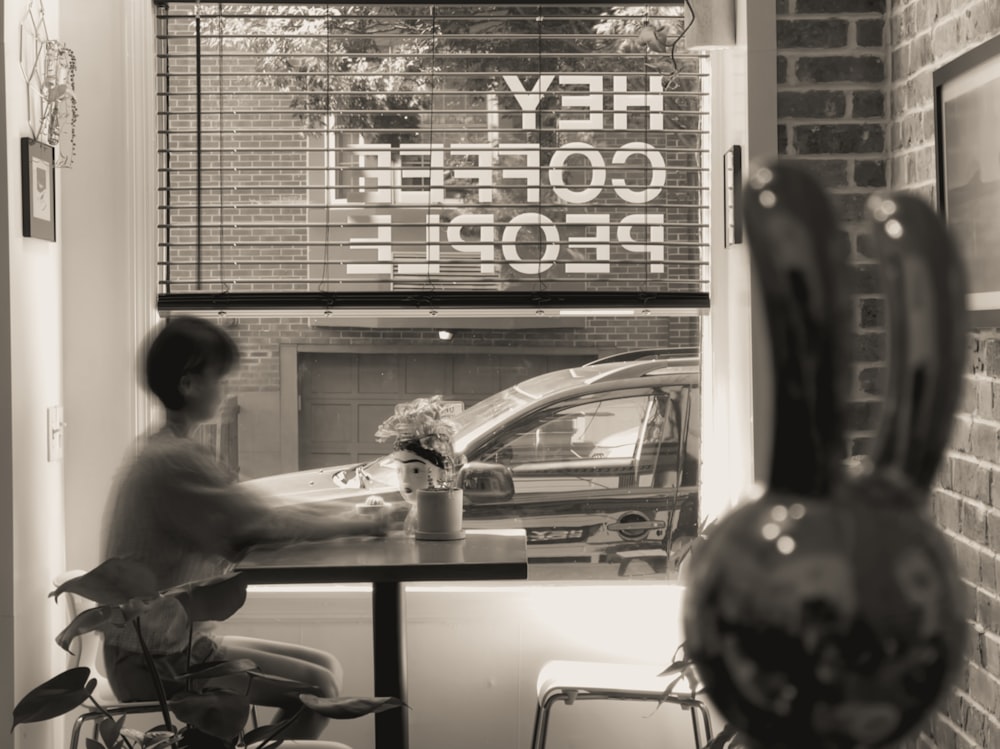 a man sitting at a table in front of a window