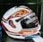 A detailed view of a motorcycle helmet with a glossy design that includes bold text and geometric patterns. The helmet features words like 'TROOPER' and 'SCRATCH RESISTANT' across the surface, with technical details and a visible visor mechanism.