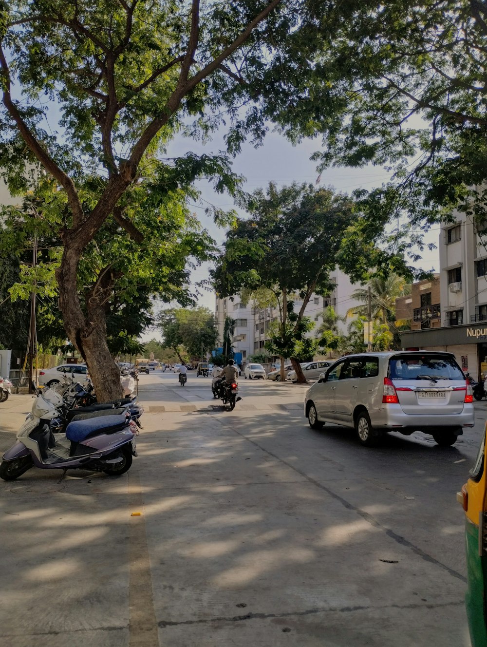 a motorcycle parked on the side of a road next to a tree