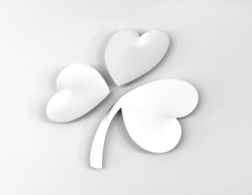 three white paper hearts on a white surface