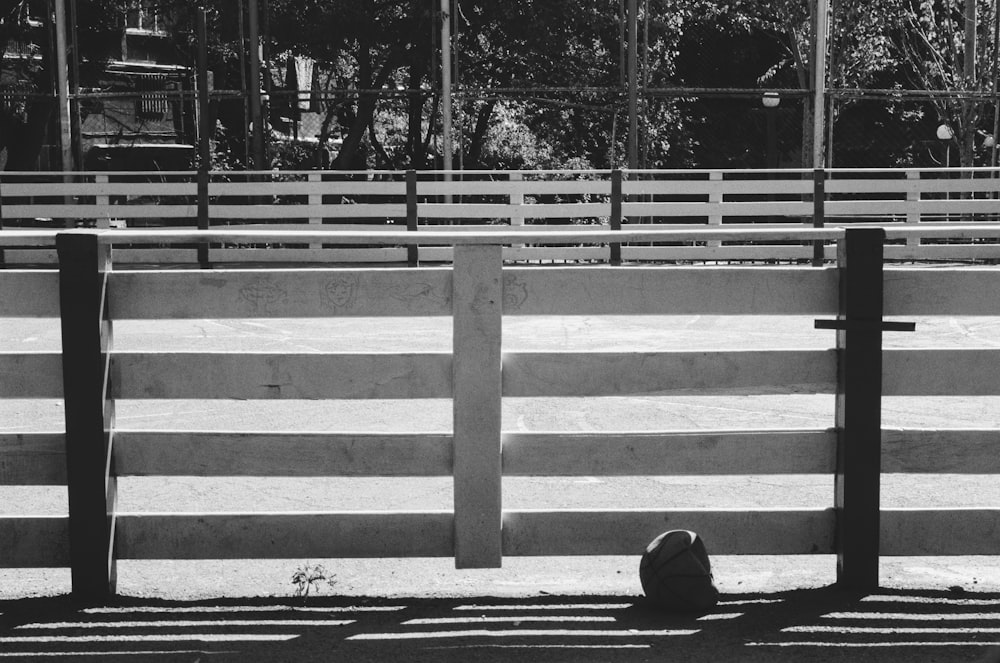 eine Person, die auf dem Boden vor einem Zaun sitzt