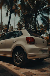 A sleek rental car parked with a tropical Curaçao airport in the background.