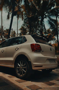 A sleek rental car parked with a tropical Curaçao airport in the background.