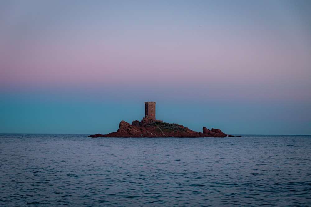 a lighthouse on a small island in the middle of the ocean