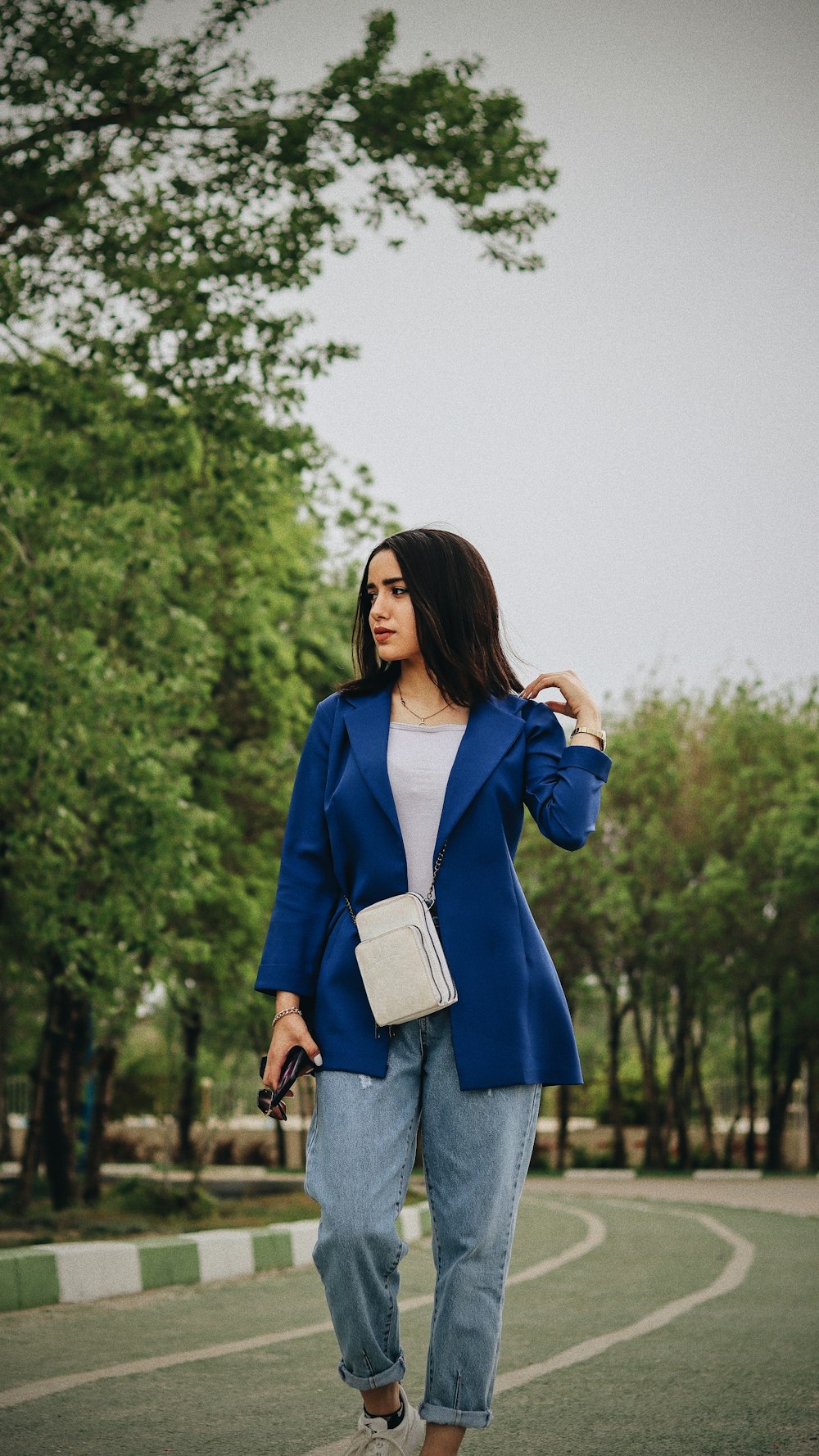 a woman wearing a blue blazer and jeans