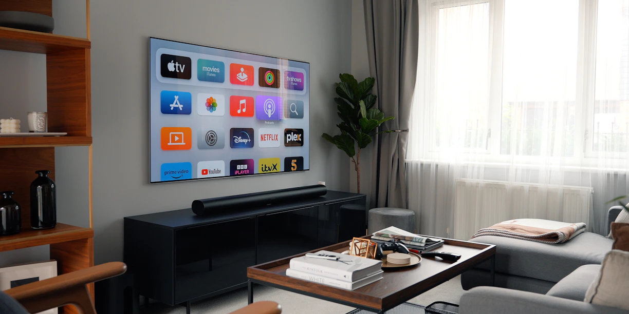 A cozy living room with a large TV showing a vibrant IPTV channel menu.