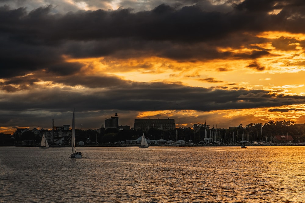 a body of water with boats on it under a cloudy sky