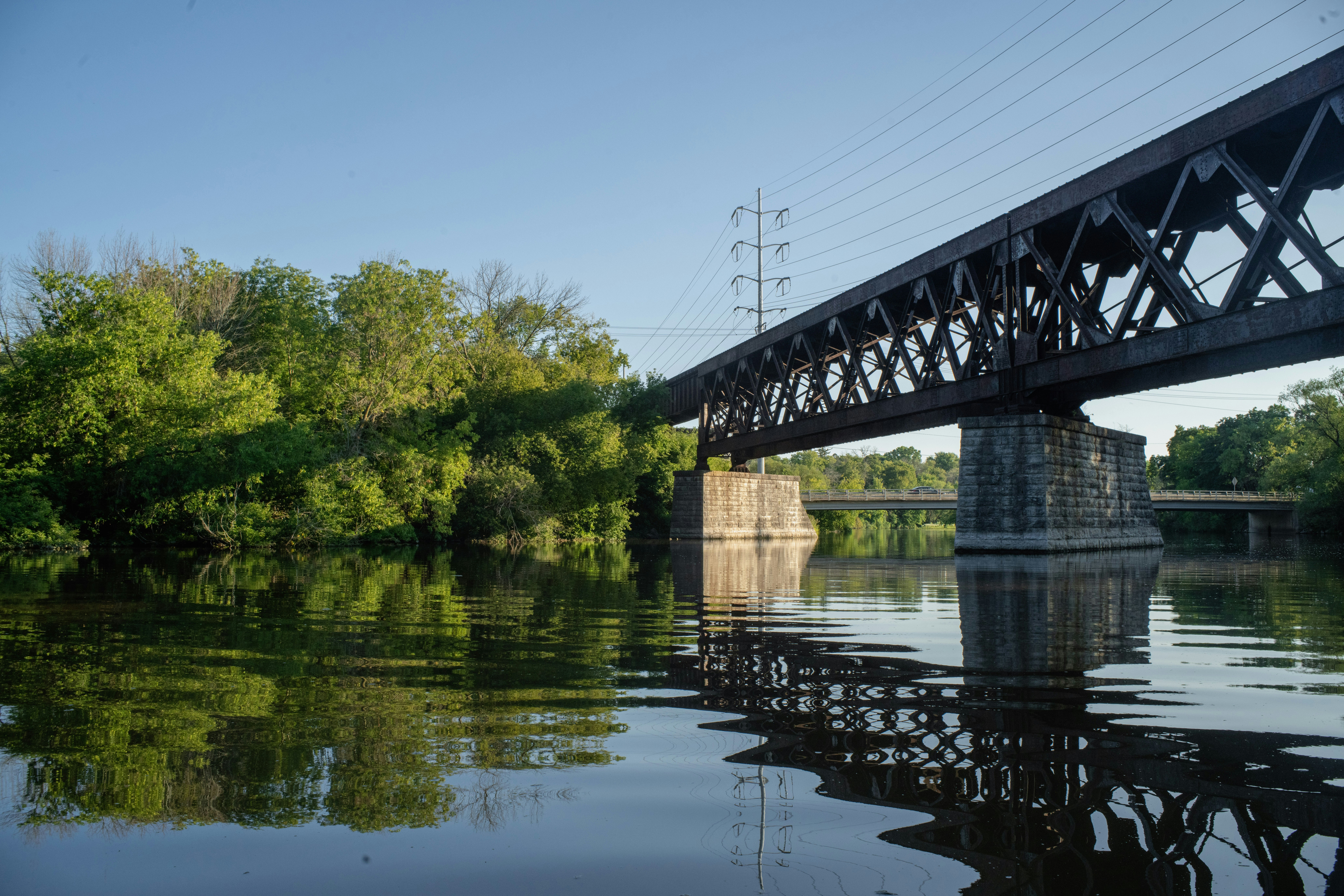 a bridge over a body of water with trees in the background
