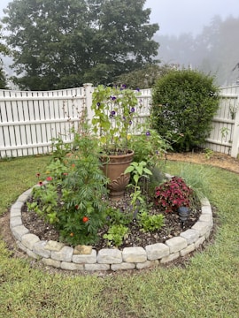 A garden bed with colorful plants bordered by a neat weed barrier