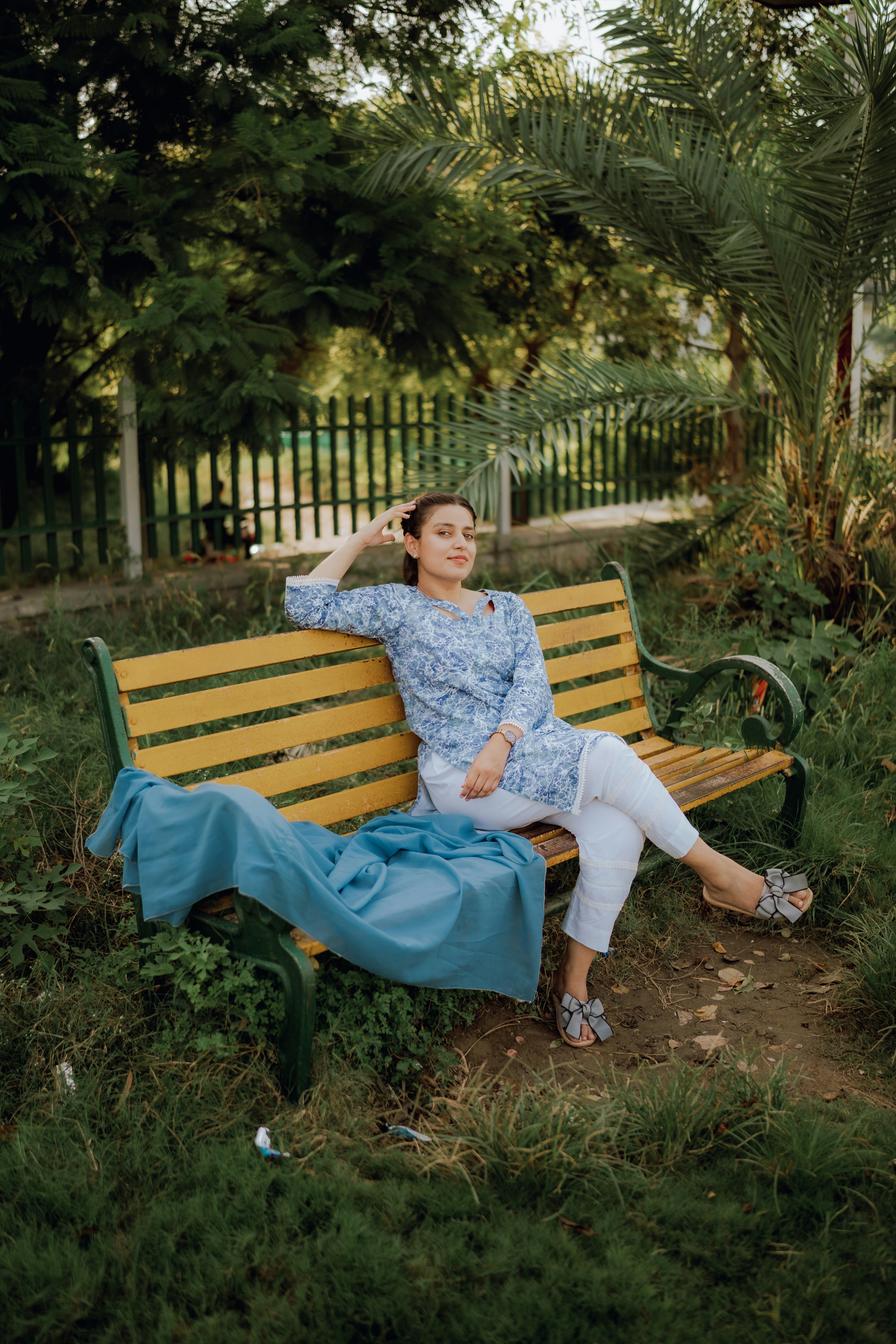 a woman sitting on a bench in a park