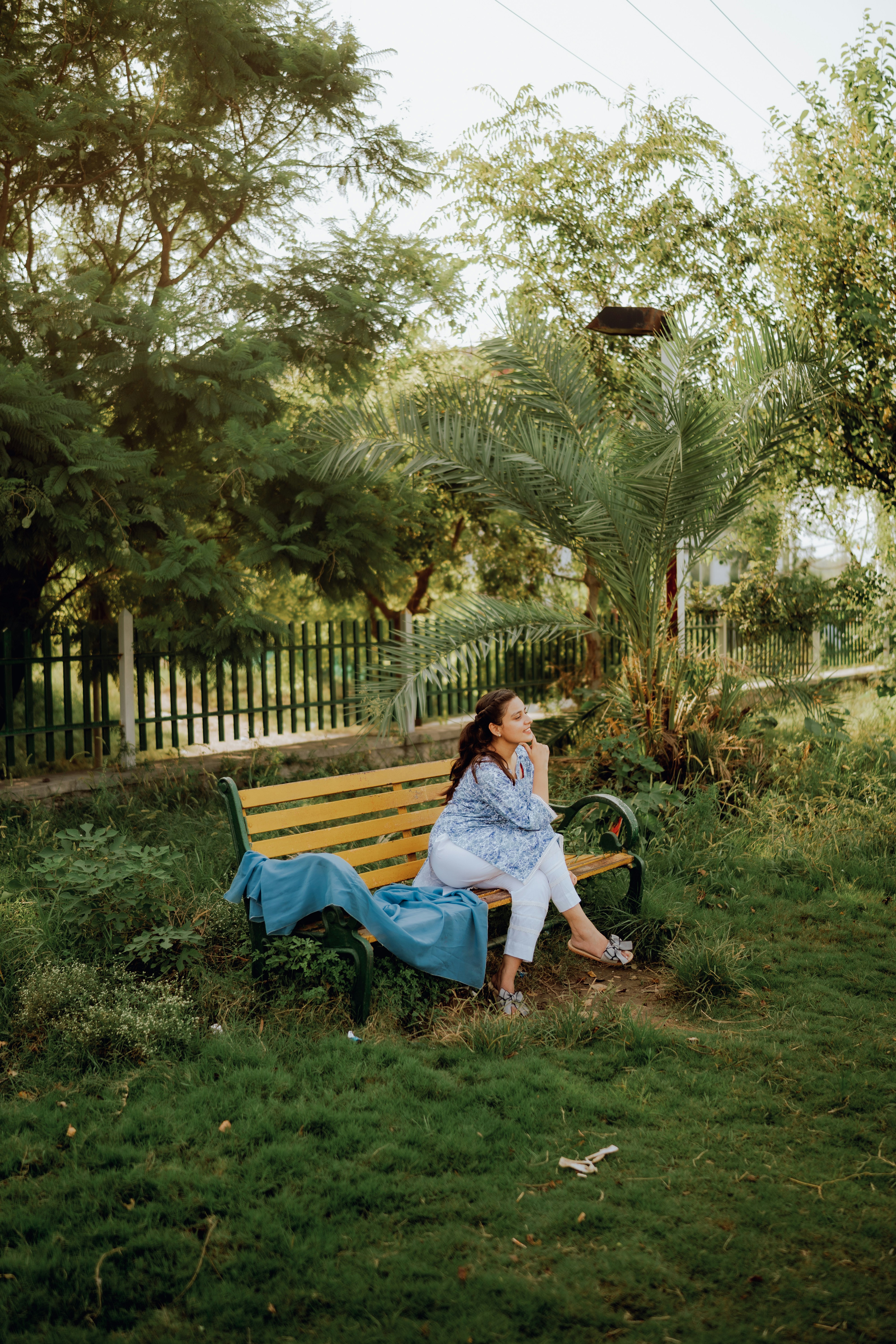a woman sitting on a bench in a park