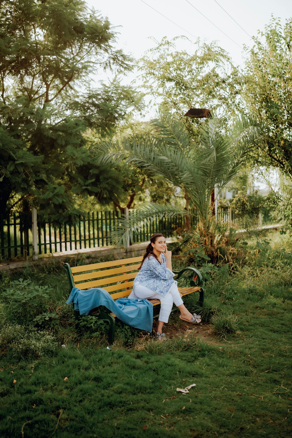 a woman sitting on a bench in a park