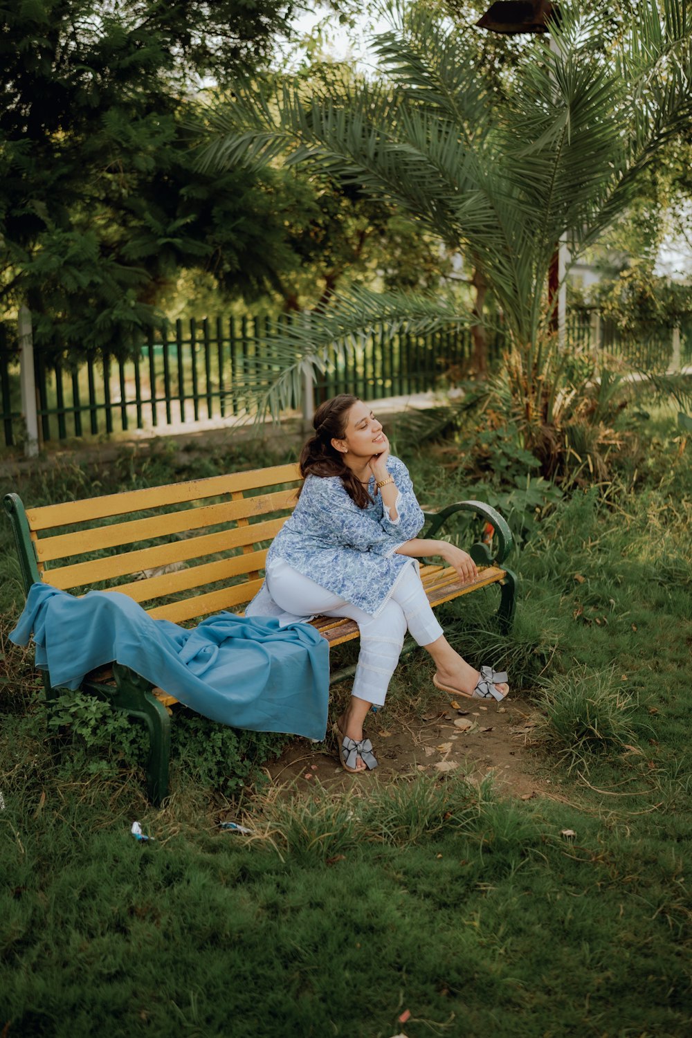 a woman sitting on a bench in a park