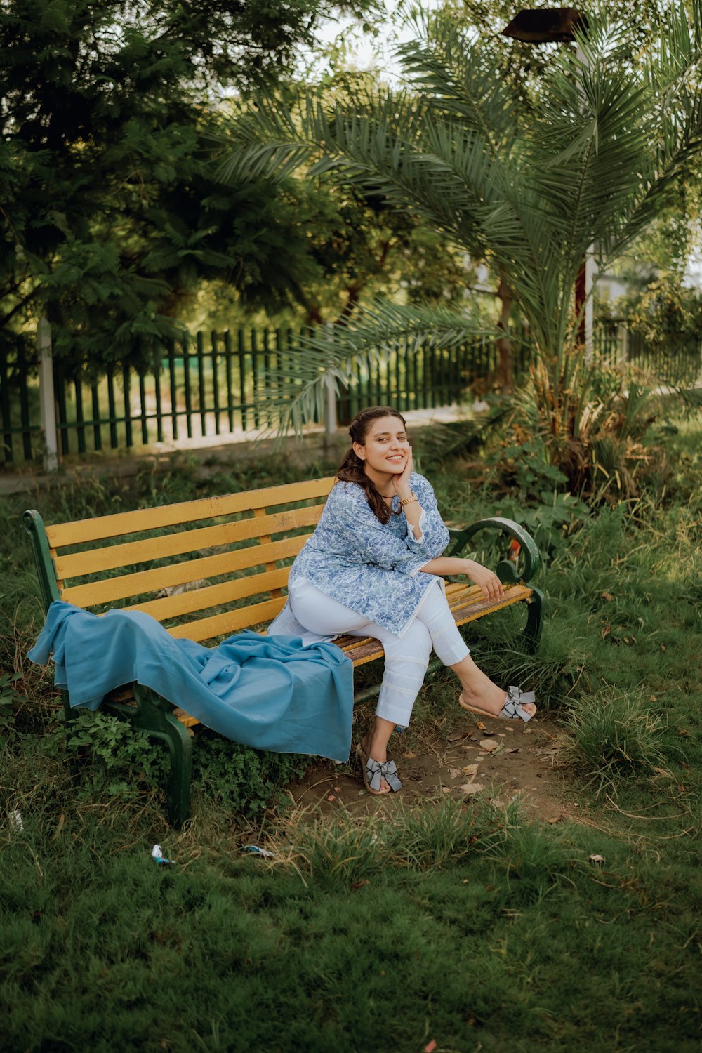 a woman sitting on a bench in a park