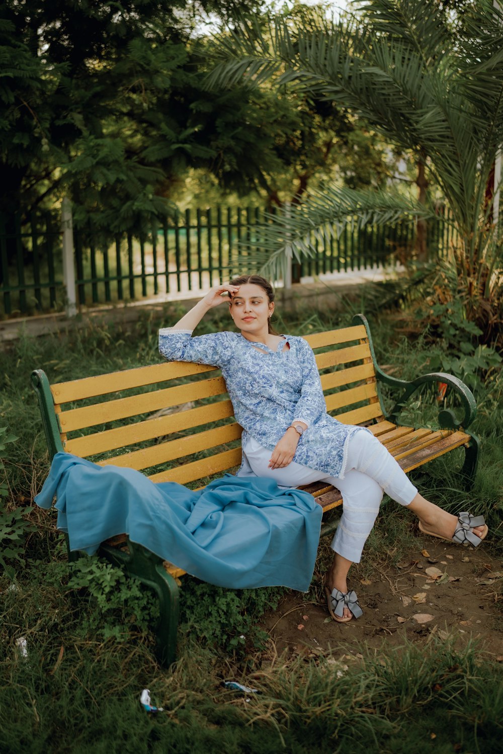 a woman sitting on a bench in a park