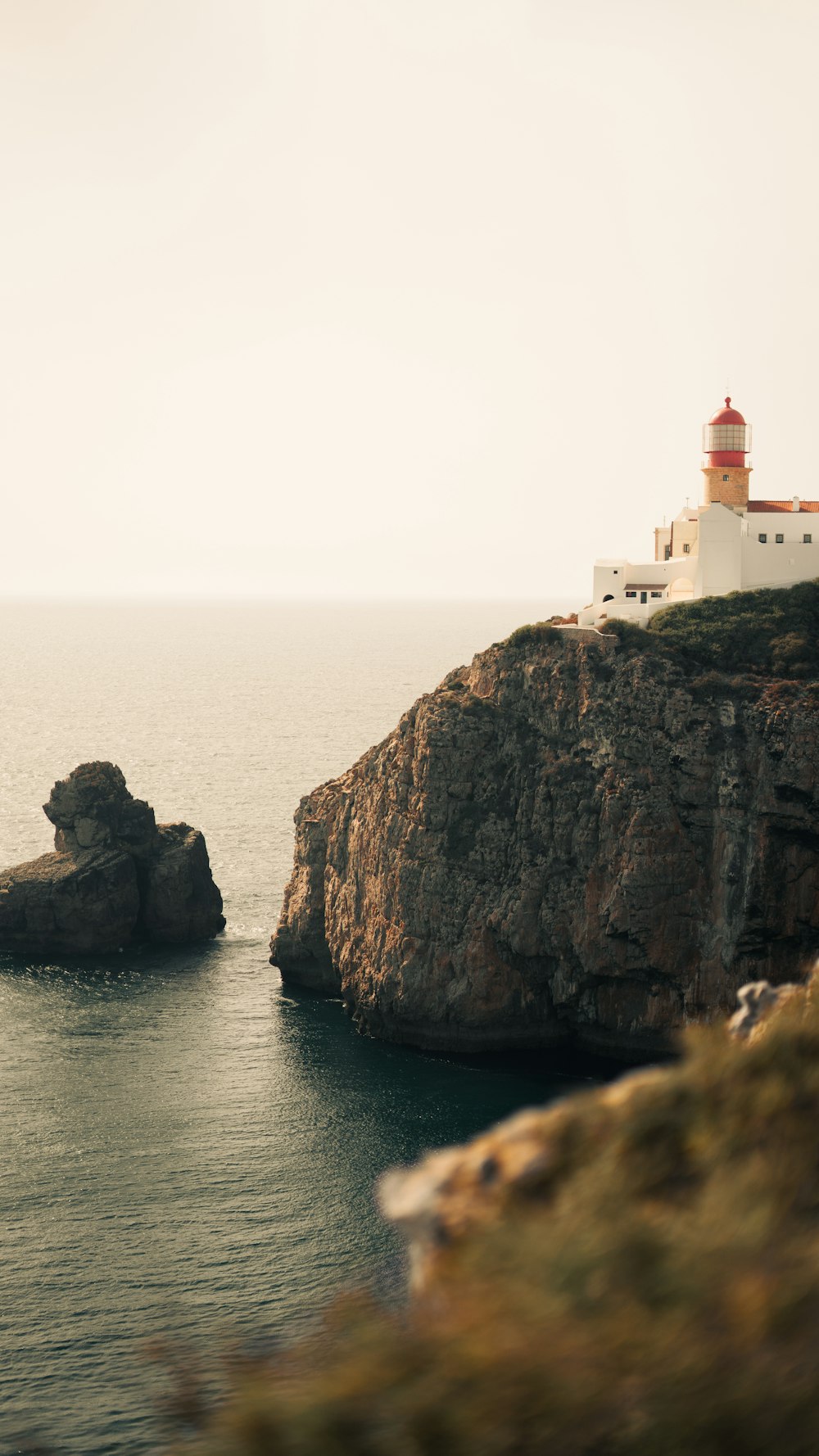 a lighthouse on top of a cliff near the ocean