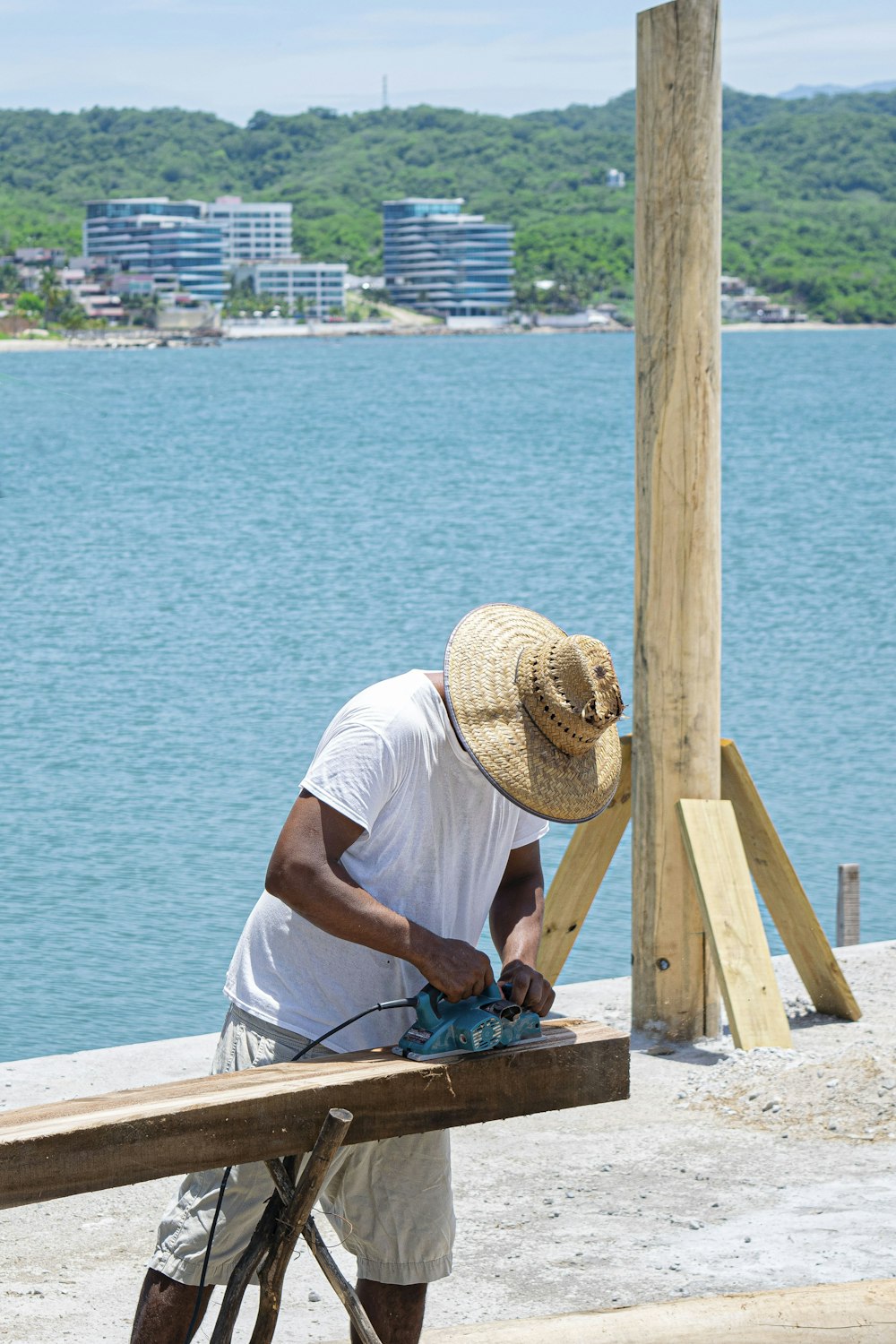 a man in a straw hat sanding next to a bicycle