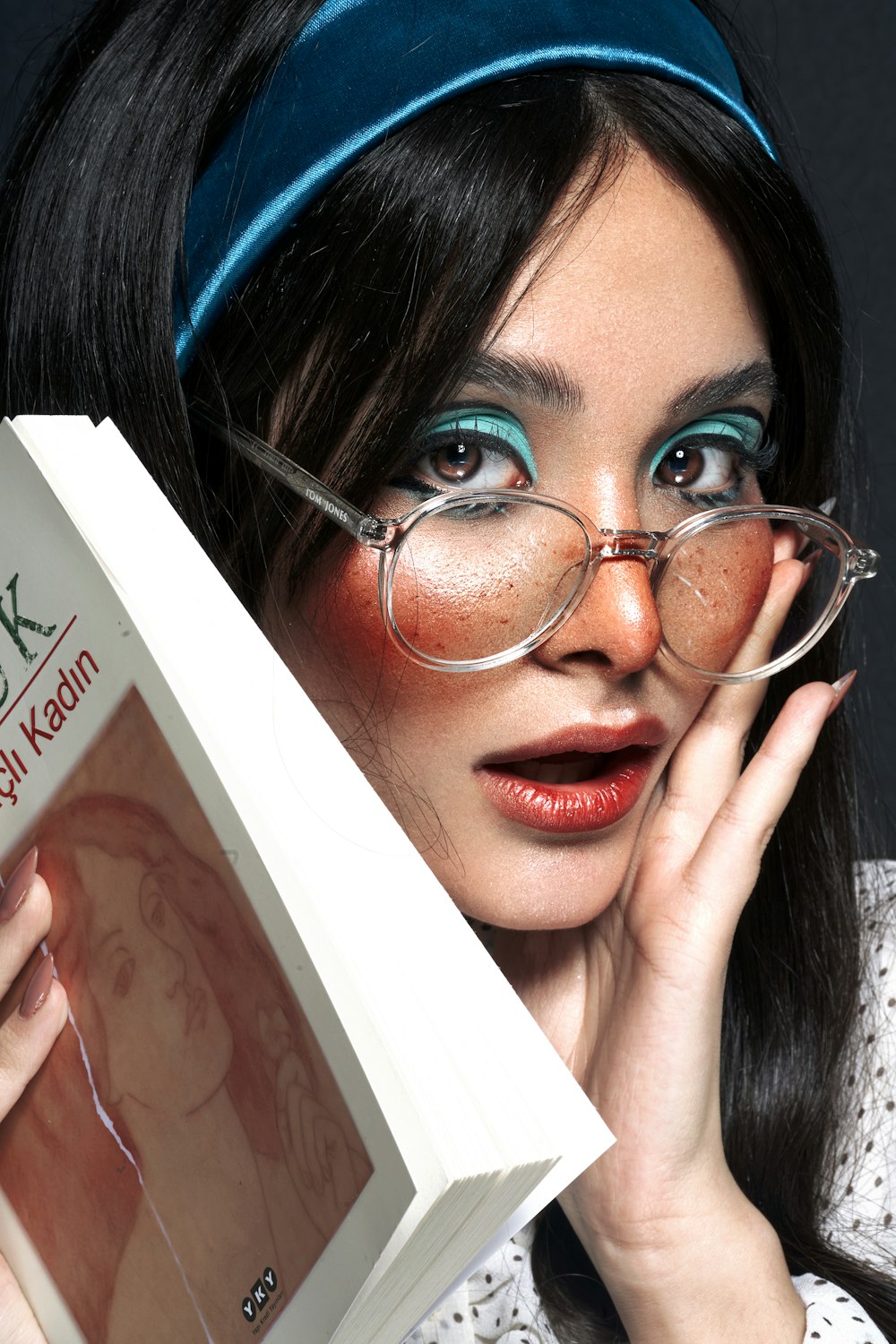 a woman wearing glasses and holding a book