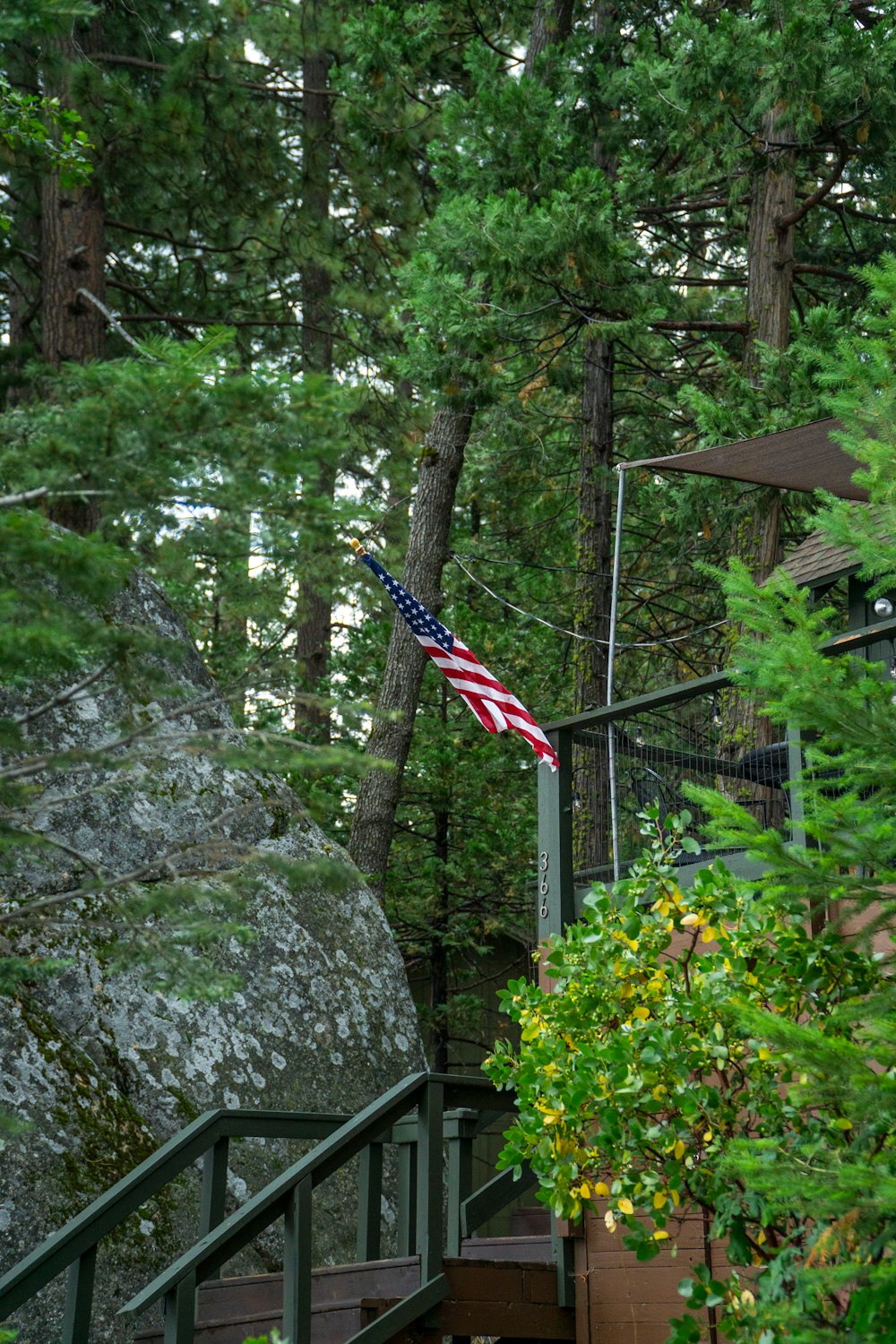 an american flag on a railing in the woods