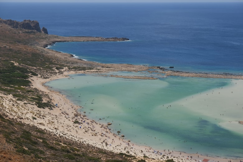 Turquoise water naast een zandstrand op Kreta