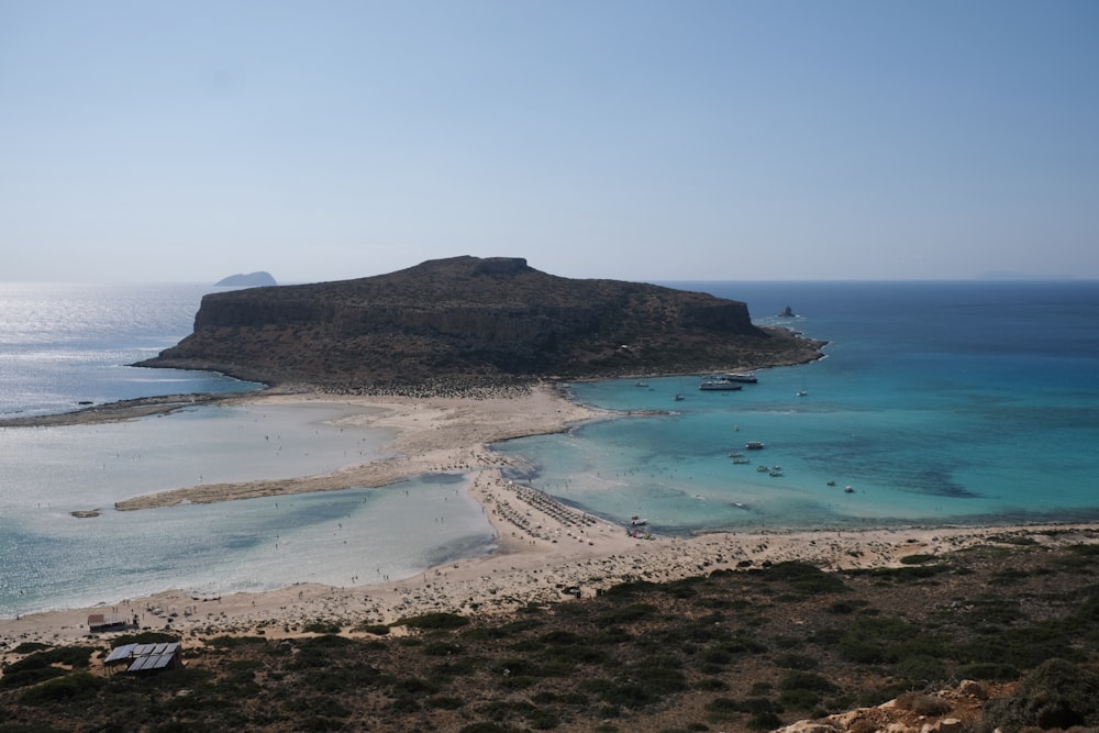 a sandy beach with a small island in the background