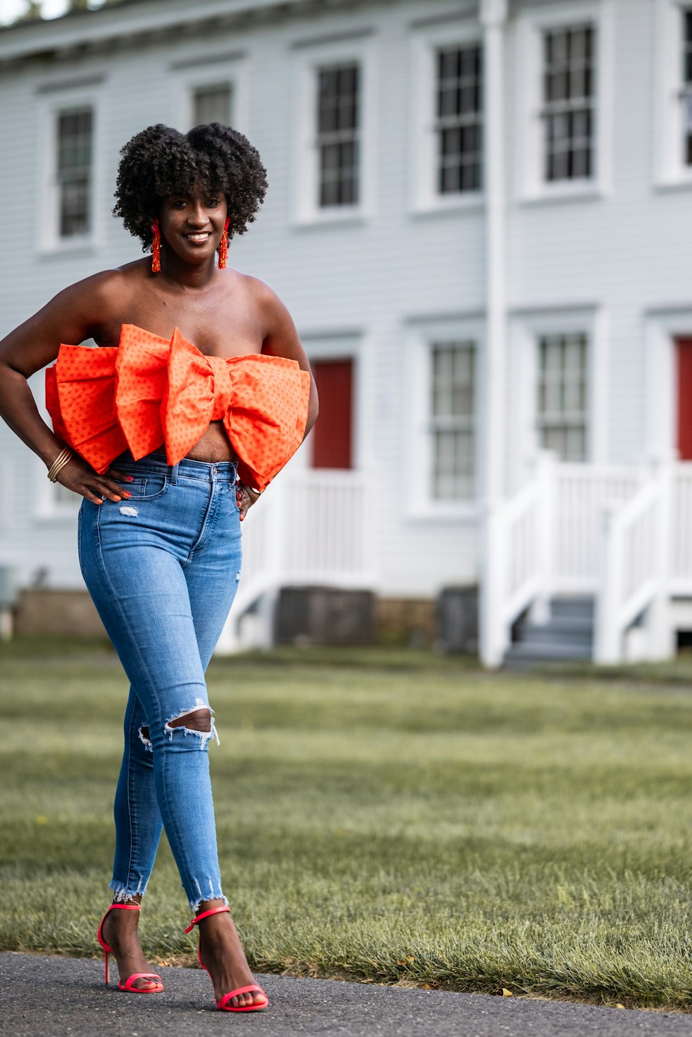 a woman standing in front of a white house