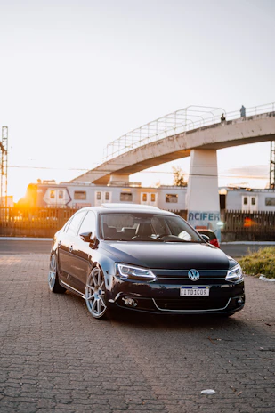 A sleek car rental parked outside a busy railway station, waiting for airport transfers.