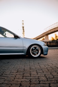 a car parked on a brick road next to a bridge