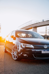 a black car parked in front of a bridge