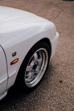 A close-up of a car with a small dent being inspected by a claims adjuster.