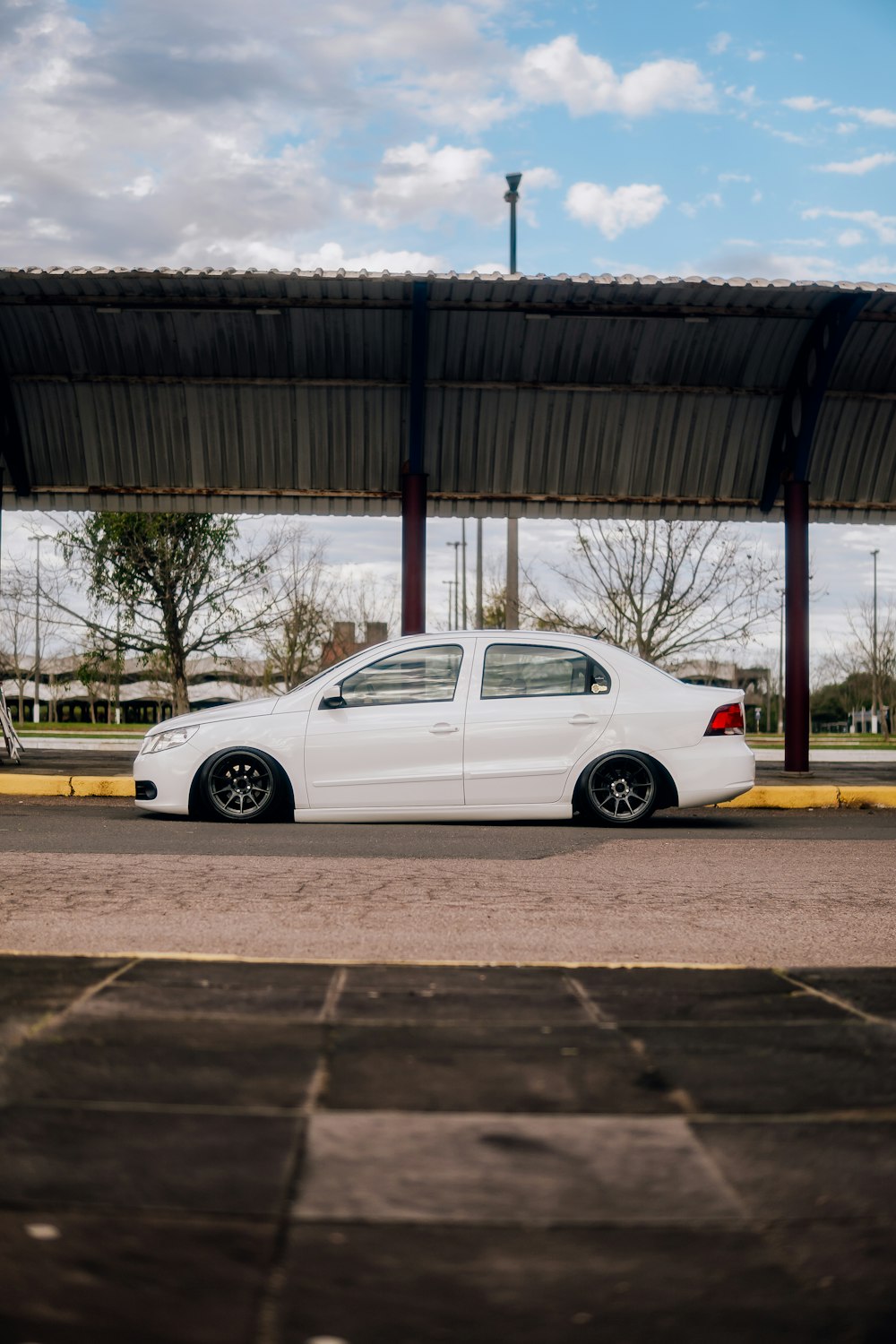 a white car parked in front of a covered parking lot