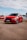 a red car parked in a parking lot next to other cars