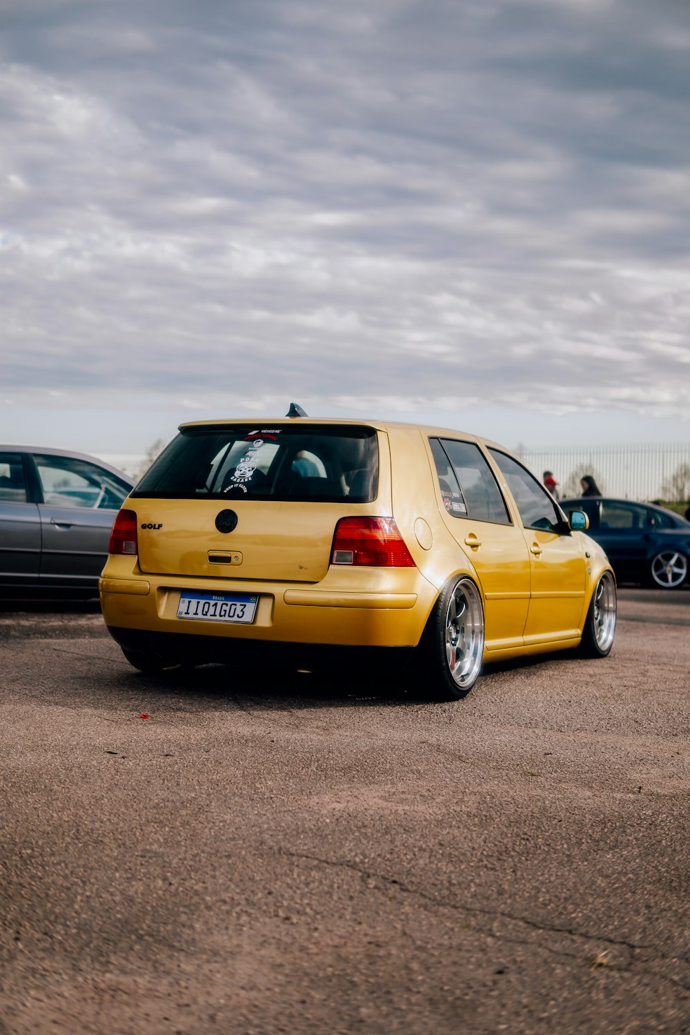 a yellow car parked in a parking lot