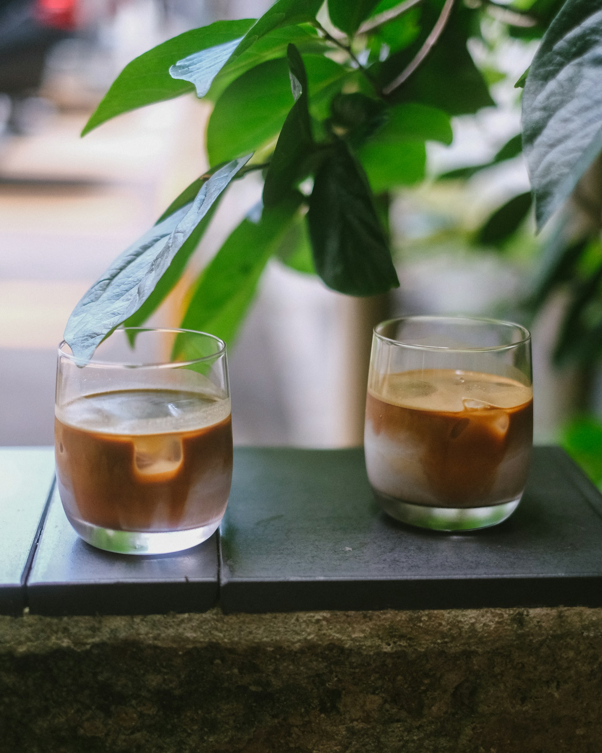 a couple of glasses of liquid sitting on top of a table