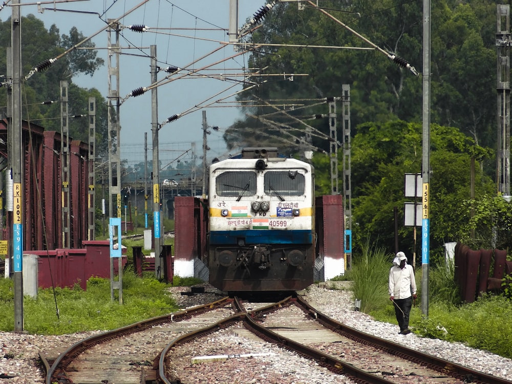 a train traveling down train tracks next to a forest