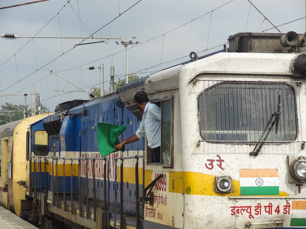 a train with a man standing on the front of it