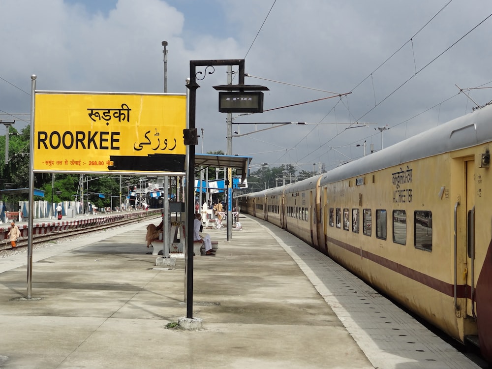 a yellow train parked next to a train station