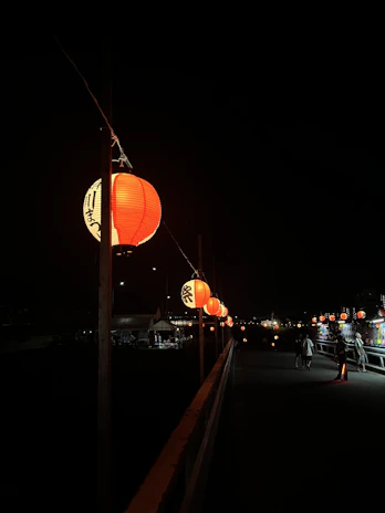 Pathway lined with lanterns leading to charming resort cabins at dusk.