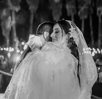 a bride hugging her groom in a black and white photo